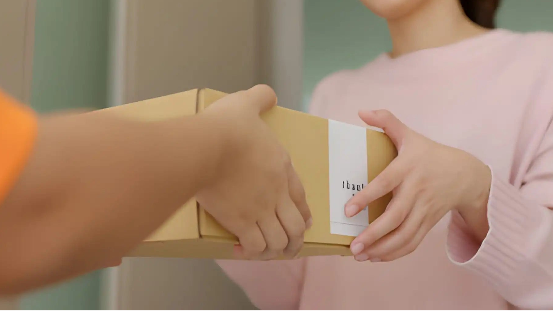 Two people exchanging a cardboard box containing CleanForge instruments with a white background